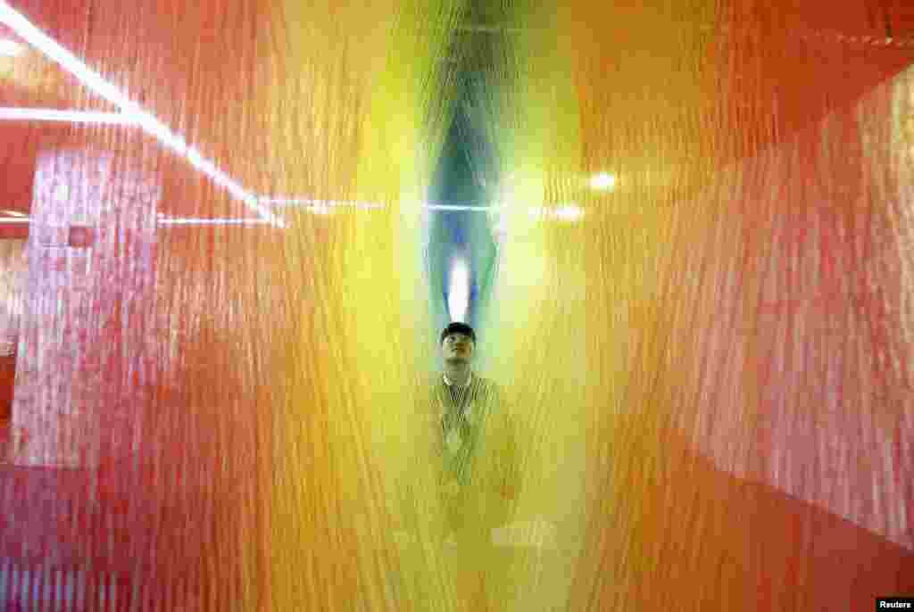 A man looks at an installation made of sock textiles on display at a demonstration hall of the local sock-making industry in Zhuji, Zhejiang province, China, Feb. 2, 2015. &nbsp;