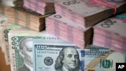 На цій ілюстрації зображено банкноти долара США та української гривні, зробленої в Києві, Україна, 31 жовтня 2016 року. REUTERS/Валентин Огіренко